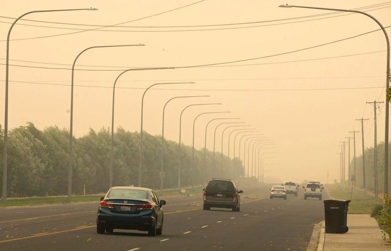 Vehicles drive down West Nob Hill Boulevard through wildfire smoke Monday, Sept. 7, 2020 in Yakima, Wash. (Evan Abell / Yakima Herald-Republic)