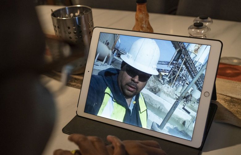 Melanese Marr-Thomas shows photographs of her late husband, Charles Thomas, at work that she keeps on her tablet, at home in District Heights, Md., on Wednesday, Sept. 21, 2022. He worked his way up at his job as a concrete truck driver and became well respected in the company – and within his community, as a known father figure to other Black boys at his youngest son’s football games. He launched a food truck and catering business, Sol Familia Mobile Kitchen, with Melanese. (AP Photo/Wong Maye-E) NYWM810 NYWM810