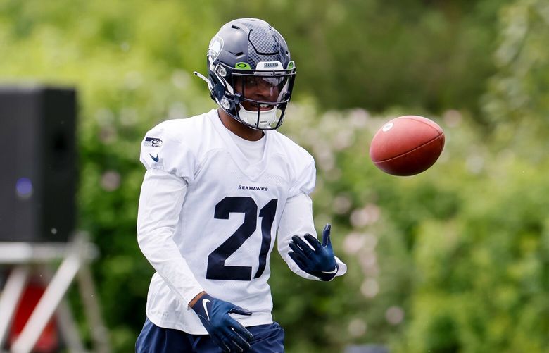 Seattle Seahawks cornerback Devon Witherspoon flips a ball back to a coach during OTAs. 223885