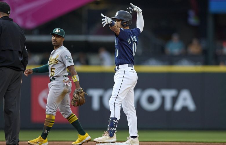 Seattle Mariners’ Sam Haggerty reacts at second base after hitting a two-run double against the Oakland Athletics, as Athletics second baseman Tony Kemp walks behind during the fourth inning of a baseball game Wednesday, May 24, 2023, in Seattle. (AP Photo/John Froschauer) WAJF112 WAJF112