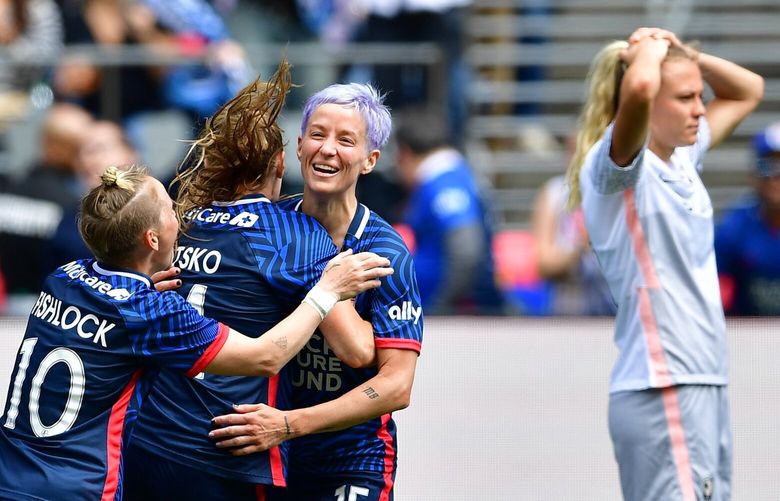 Jess Fishlock, left, and Megan Rapinoe, right, congratulate Veronica Latsko on one of her two goals in the OL Reign’s 4-1 win over Angel City FC on Saturday May 27, 2023 at Lumen Field in Seattle.