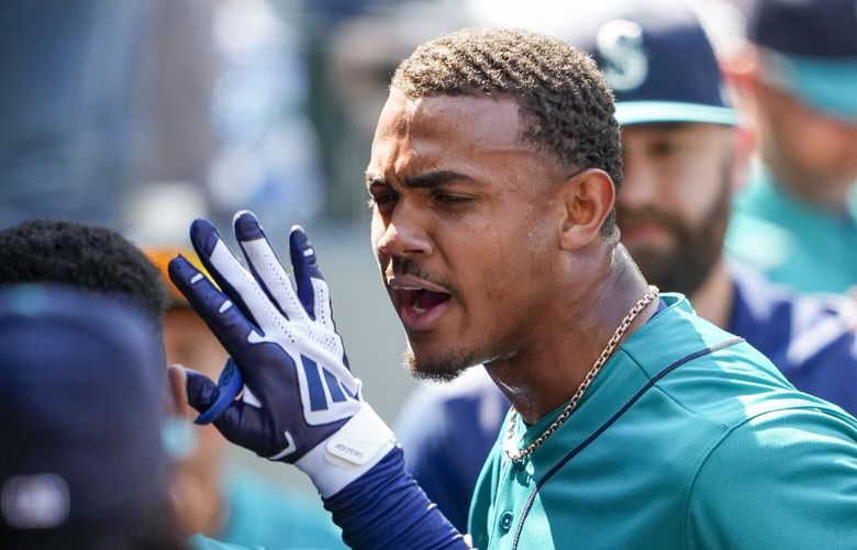 Seattle Mariners’ Julio Rodriguez reacts in the dugout after scoring against the Pittsburgh Pirates on a sacrifice fly by Eugenio Suarez during the seventh inning of a baseball game Saturday, May 27, 2023, in Seattle. Rodriguez was initially called out at home plate but the call was overturned following a challenge from the Mariners. (AP Photo/Lindsey Wasson) WALW131 WALW131