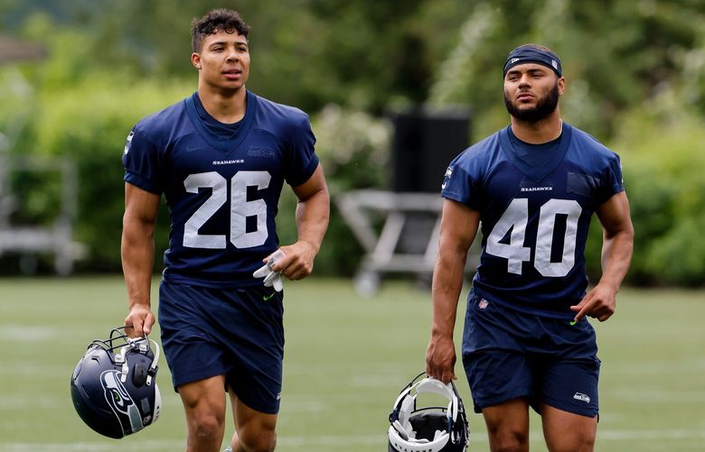 Seattle Seahawks running back Zach Charbonnet, left, and running back Bryant Koback jog off the field after the first day of OTAs. 223885