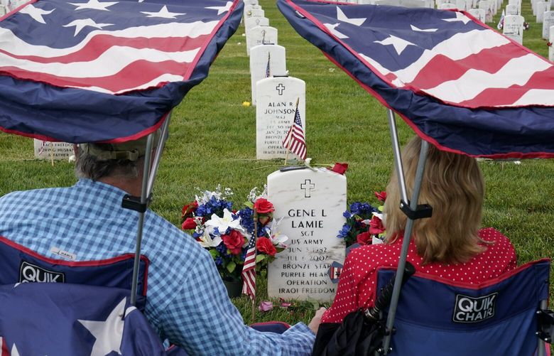 Eugene and Linda Lamie, of Homerville, Ga., sit by the grave of their son U.S. Army Sgt. Gene Lamie in Section 60 at Arlington National Cemetery on Memorial Day, Monday, May 29, 2023, in Arlington, Va. (AP Photo/Alex Brandon) VAAB402 VAAB402