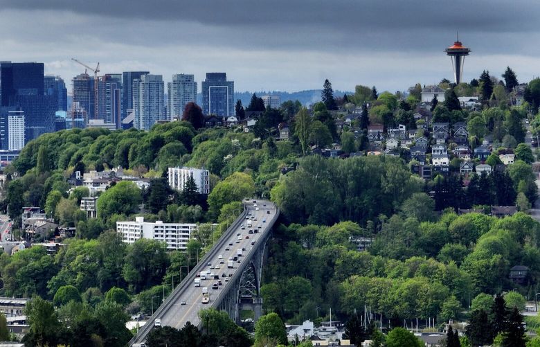 Springtime has brought in lush foliage, as downtown Seattle apartment buildings are seen to the left of Queen Anne Hill and the Space Needle, as traffic moves over the Aurora bridge, Thursday, May 4, 2023 in Seattle.