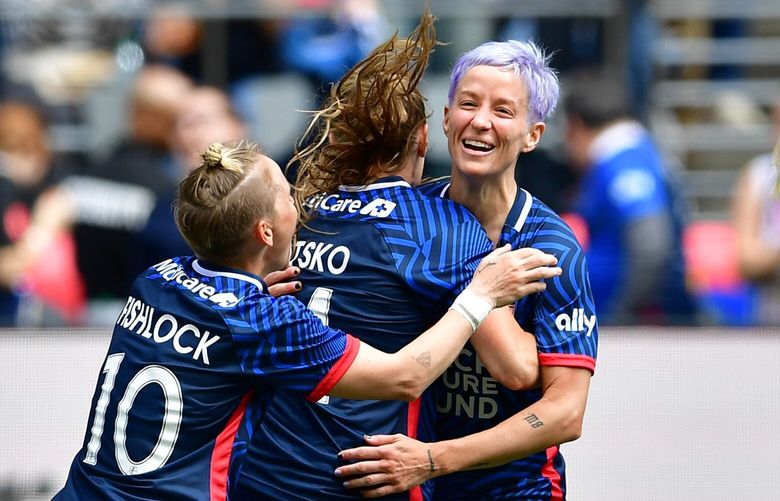 Jess Fishlock, left, and Megan Rapinoe, right, congratulate Veronica Latsko on one of her two goals in the OL Reign’s 4-1 win over Angel City FC on Saturday May 27, 2023 at Lumen Field in Seattle.
