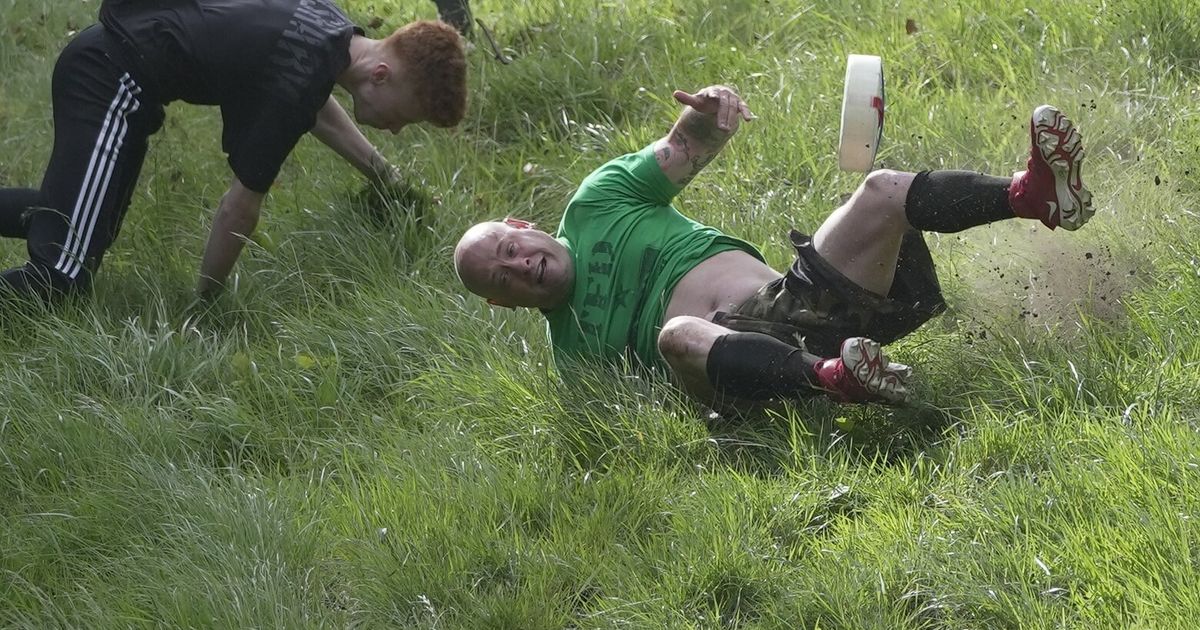 Rolling thunder Contestants chase cheese wheel down a hill in chaotic