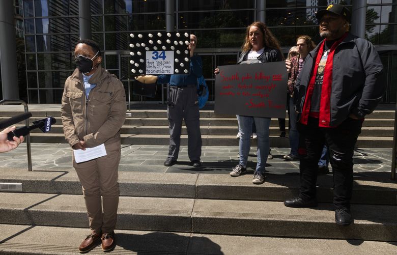 Castill Hightower, left, whose brother Herbert L. Hightower was killed in a police officer shooting in 2004, talks to the news media after a hearing on a consent decree implemented in 2012 for the Seattle Police Department is held in the Federal Courthouse in the background, Tuesday, May 30, 2023 in Seattle. (Ken Lambert / The Seattle Times)