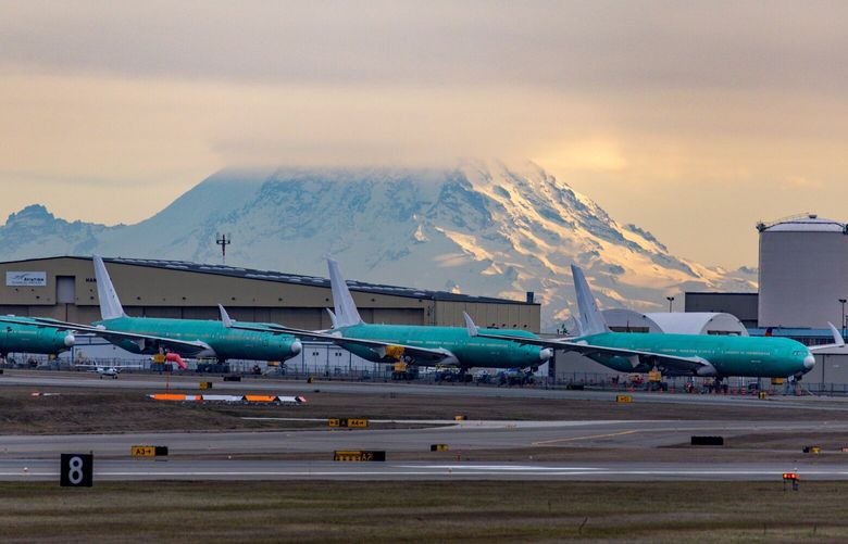 Mt. Rainier looms above a line of unfinished Boeing 777X aircraft at Paine Field, Monday, Jan. 30, 2023. 222921