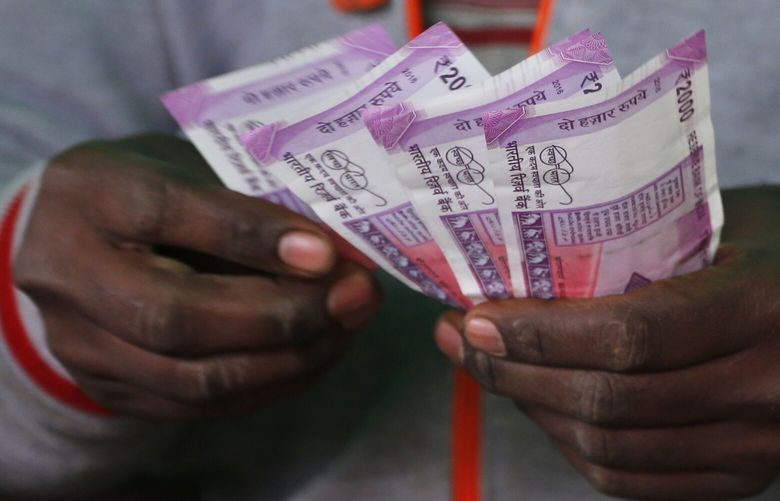 A trader counts new 2,000-rupee notes at a wholesale vegetable market in Bangalore, India, Friday, Dec. 30, 2016. India yanked most of its currency bills from circulation without warning, delivering a jolt to the country’s high-performing economy and leaving countless citizens scrambling for cash. Still, as Friday’s deadline for depositing old 500- and 1,000-rupee notes draws to a close, Prime Minister Narendra Modi’s government has called the demonetization drive a great success in drawing out tax dodgers and eliminating graft. (AP Photo/Aijaz Rahi)