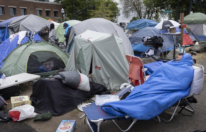 Residents of this controversial homeless encampment in downtown Burien hang out Wednesday morning, May 31, 2023.  The camp is at the intersection of SW 152nd St. and 6th Ave. SW and is currently scheduled to be cleared Wednesday, May 31 at midnight.  224059