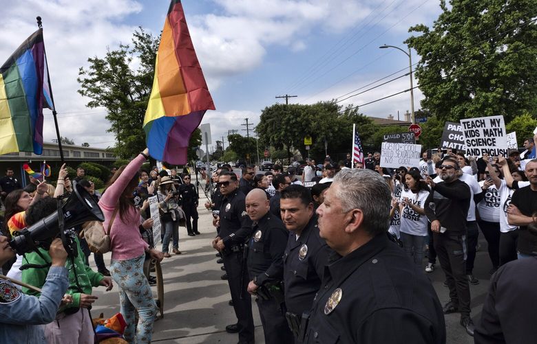 Los Angeles police officers separate protestors at the Saticoy Elementary School in the North Hollywood section of Los Angeles on Friday, June 2, 2023.  Police officers separated groups of protesters and counter-protesters outside the Los Angeles elementary school that has become a flashpoint for Pride month events across California. (AP Photo/Richard Vogel) LA501 LA501