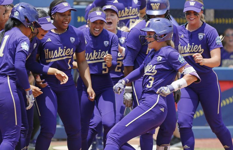 Washington celebrates a home run by Rylee Holtorf (3) at home plate during the second inning of an NCAA softball Women’s College World Series game against Utah Friday, June 2, 2023, in Oklahoma City. (AP Photo/Nate Billings) OKNB105 OKNB105