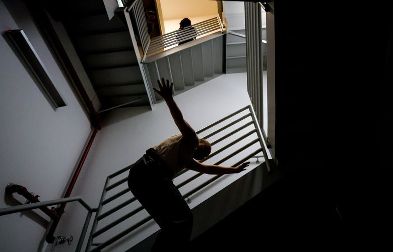 Other dancers watch as Sofiya Kostareva performs at the base of a fire escape staircase within the Inscape building.  224014