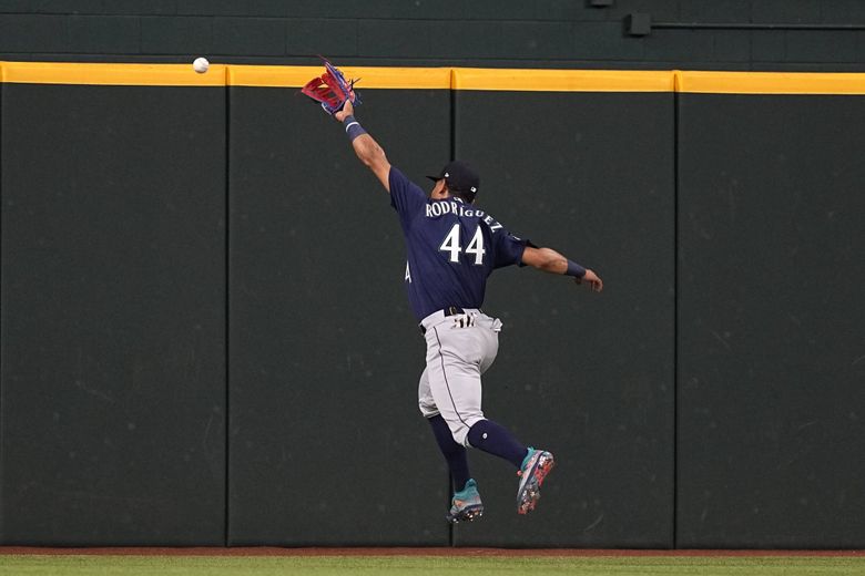 Seattle Mariners center fielder Julio Rodriguez is unable to catch up to a Texas Rangers’ Adolis Garcia run-scoring double in the third inning of a baseball game, Sunday, in Arlington, Texas. (Tony Gutierrez / The Associated Press)