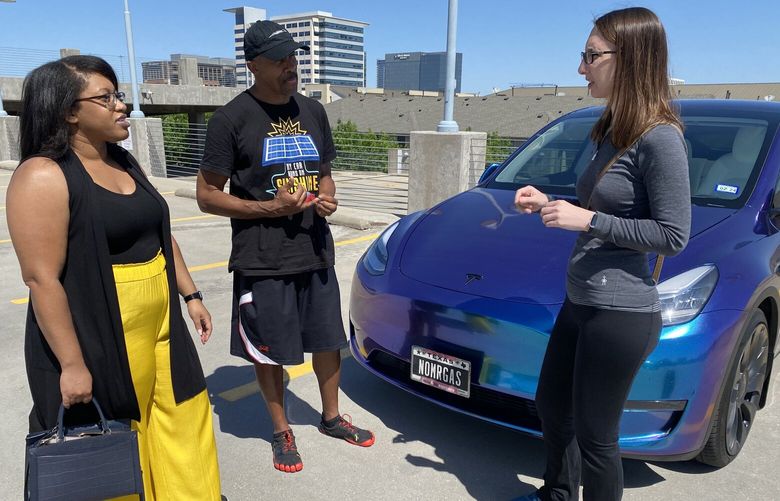 Shawna Spence, John Packer and Lindsey Perkins, members of a club for Tesla owners, chat at a charging station in Plano, Tex. MUST CREDIT: Washington Post photo by Jeanne Whalen