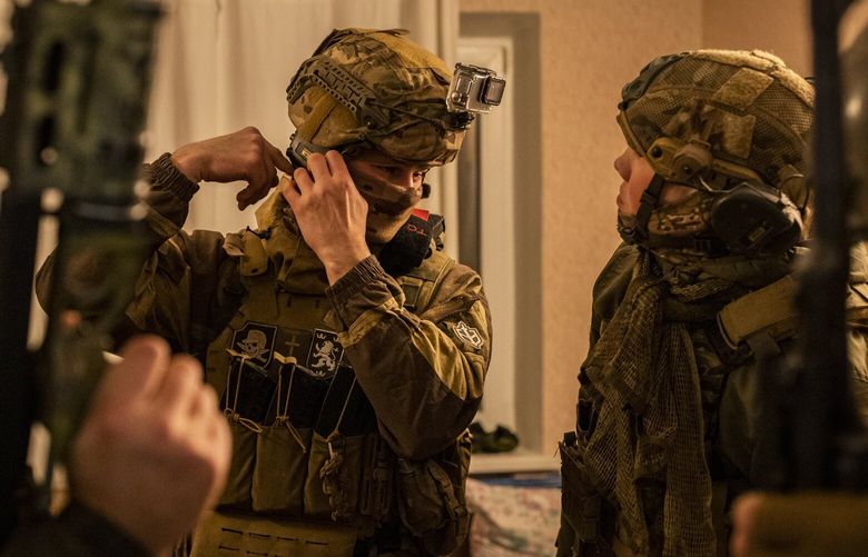FILE – A Russian volunteer fighter for the Ukrainian army, center, wearing a Galizien patch and another featuring a Totenkopf in southern Ukraine on Nov. 5, 2022. Ukrainian troops’ use of patches bearing Nazi emblems risks fueling Russian propaganda and spreading imagery that the West has spent a half-century trying to eliminate. (Ivor Prickett/The New York Times) XNYT0485