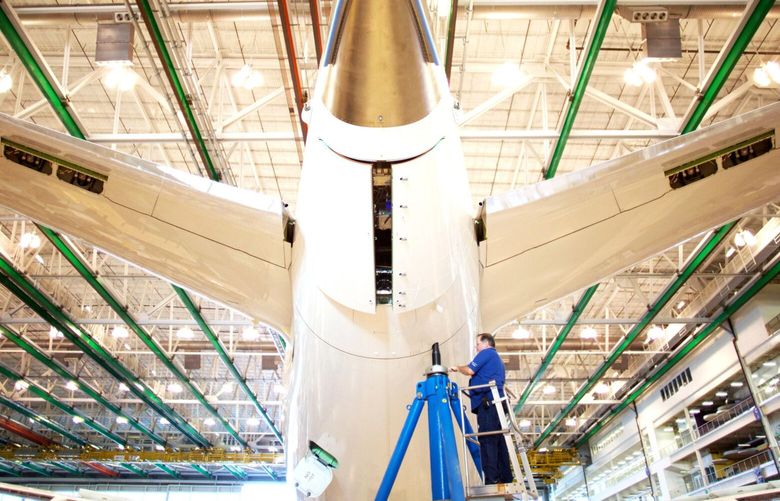 An employee works on the tail of a Boeing Co. Dreamliner 787 plane on the production line at the company’s final assembly facility in North Charleston, South Carolina, U.S., on Tuesday, Dec. 6, 2016. On the day President-elect Donald Trump lashed out at Boeing Co. for the cost of replacing Air Force One, mechanics and engineers at the planemaker’s South Carolina factory were focused on another challenge: making the first 787-10 Dreamliner. The manufacturer is counting on the newest and longest Dreamliner to help turn its marquee carbon-fiber jet into a cash machine. Photographer: Travis Dove/Bloomberg