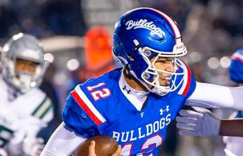 Folsom Bulldogs quarterback Austin Mack tries to fend off De La Salle Spartan outside linebacker Andrew Cunningham (18) during the Division I-A CIF Northern California Regional Championship game in December. (Xavier Mascareñas / The Sacramento Bee / TNS)