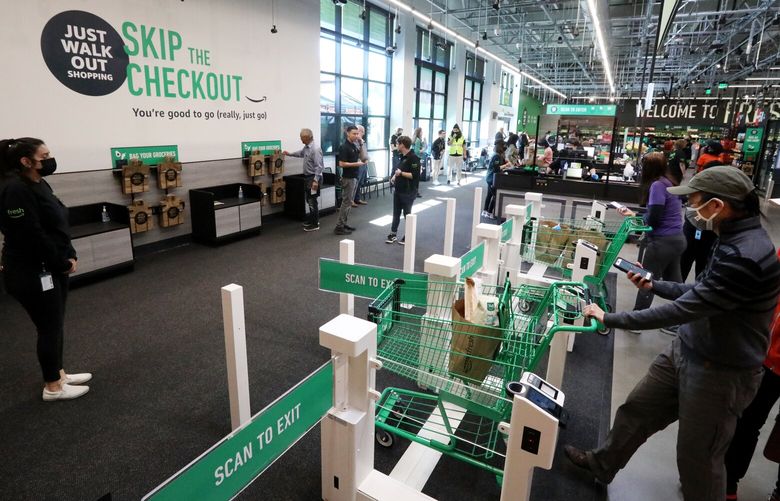 Customers using cashierless technology to checkout with an app or credit card at the first Amazon Fresh in the state, on opening day, Thursday, June 17, 2021 in Bellevue. The store also has cashiers. 217422