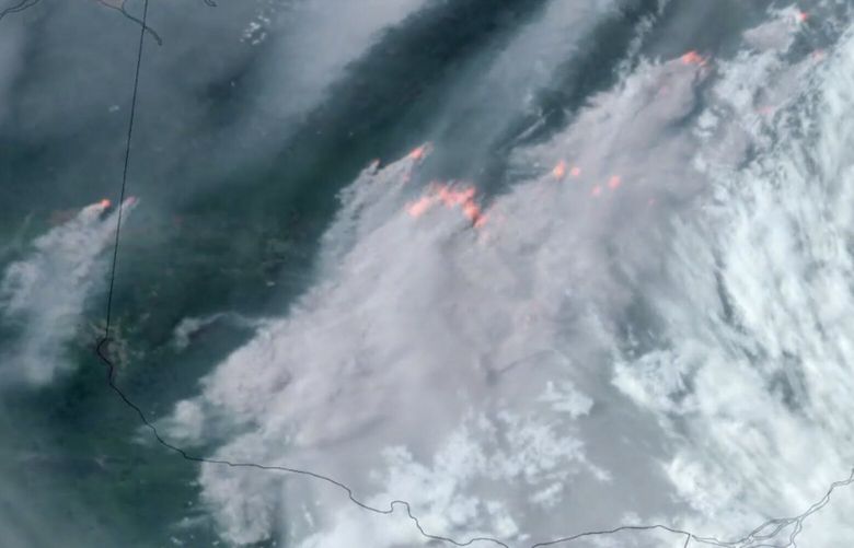In this GOES-16 GeoColor and fire temperature satellite image taken Tuesday, June 6, 2023 at 6:40 p.m. EDT and provided by CIRA/NOAA, smoke from wildfires burning in the Canadian Provinces of Quebec, right, and Ontario, left, drift southward. (CIRA/NOAA via AP) NYDD202 NYDD202