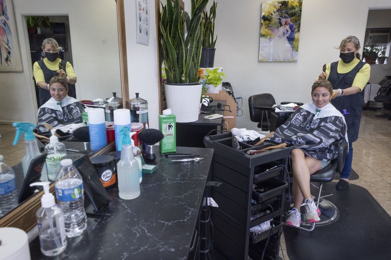 Mariana García, owner of Fantástica Beauty Salon in Burien, works on Itsi Gomez&#8217;s hair at her salon last month. (Ellen M. Banner / The Seattle Times)
