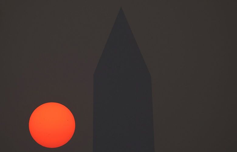 The sun rises behind the Washington Monument and a thick layer of smoke, Thursday, June 8, 2023, in Washington. Intense Canadian wildfires are blanketing the northeastern U.S. in a dystopian haze, turning the air acrid, the sky yellowish gray and prompting warnings for vulnerable populations to stay inside. (AP Photo/Julio Cortez) MDJC101 MDJC101
