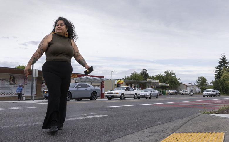 Roxana Pardo Garcia crosses Ambaum Boulevard Southwest at Southwest 136th Street last month. Pardo Garcia is a community leader who was hired by Burien to help the city collect input about a new vision for the Ambaum Boulevard corridor. (Ellen M. Banner / The Seattle Times)