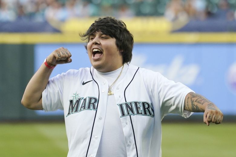 Travis Thompson, a rapper from Burien, reacts after throwing out the first pitch of a baseball game between the Mariners and the Washington Nationals in 2022. (Ted S. Warren / The Associated Press)