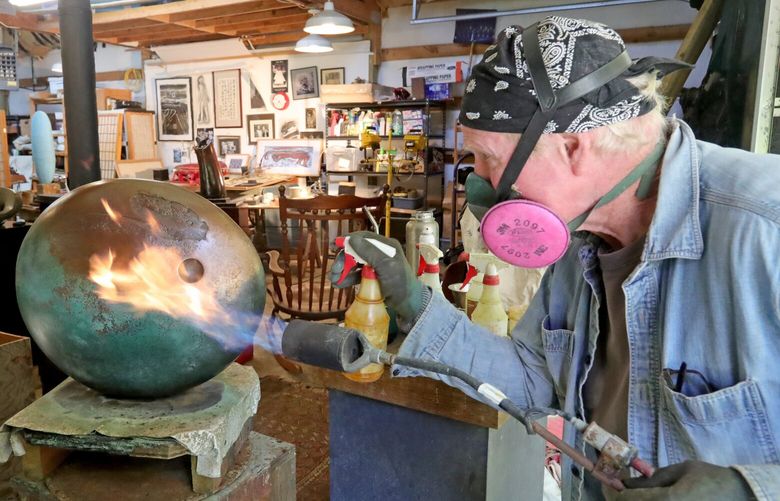 NW Sculptor and painter Jeff Day is having a show of his work at Smith & Vallee gallery in Bow-Edison, Wa at the end of this June. He is busy working on his sculptures for the the show at his Whidbey Island studio.
He’s using a propane torch to heat up the 50-pound bronze sculpture, “Sun Break” occasionally spraying ferric nitrate or copper nitrate to add pattina to the piece.
224104