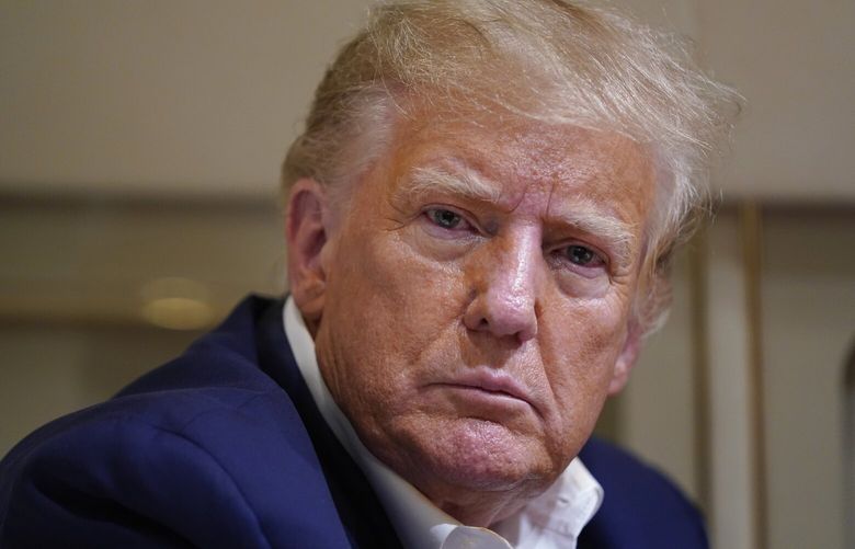 FILE – Former President Donald Trump listens as he speaks with reporters while in flight on his plane after a campaign rally at Waco Regional Airport, in Waco, Texas, March 25, 2023, while en route to West Palm Beach, Fla. (AP Photo/Evan Vucci, File) WX406 WX406