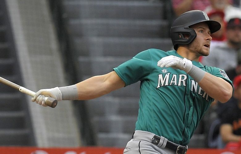 CORRECTS TO TWO-RUN HOME RUN NOT A SOLO HOME RUN – Seattle Mariners’ Jarred Kelenic, right, hits a two-run home run as Los Angeles Angels catcher Chad Wallach watches during the first inning of a baseball game Friday, June 9, 2023, in Anaheim, Calif. (AP Photo/Mark J. Terrill) ANS117 ANS117