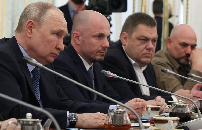 Russian President Vladimir Putin, left, attends a meeting with Russian war correspondents who cover a special military operation at the Kremlin in Moscow, Russia, Tuesday, June 13, 2023. (Gavriil Grigorov, Sputnik, Kremlin Pool Photo via AP) XAZ108 XAZ108