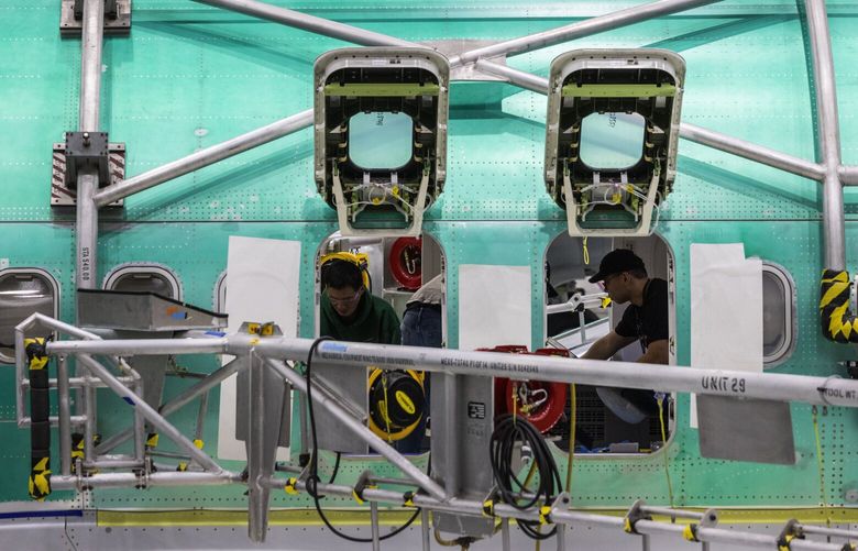 First-shift workers at the Boeing Renton factory are seen inside a 737 MAX being assembled on the Central line, Thursday, March 9, 2023 in Renton. 223254