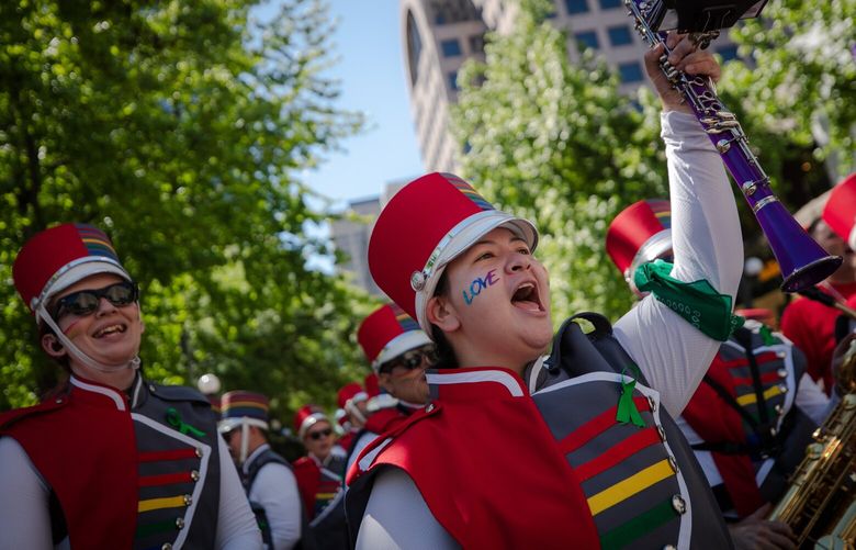 Members of rainbow city marching band cheer ahead of the Pride Parade in Downtown Seattle on June 26, 2022.