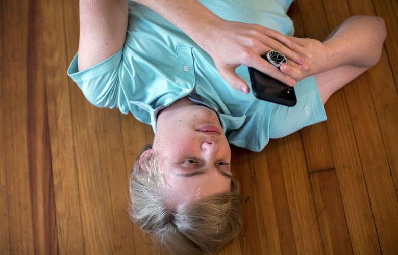 FILE —  A fifteen-year-old using his smartphone in Metter, Ga. on April 26, 2021. While many scientists share the concern, there is little research to prove that social media is harmful — or to indicate which sites, apps or features are problematic. (Stephen B. Morton/The New York Times) XNYT0542 XNYT0542