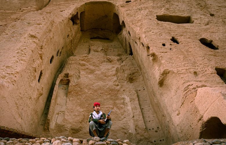 A young guard sits last month near the cavity where one of the two 1,500-year-old Buddha statues stood before the Taliban destroyed them in 2001. (MUST CREDIT: Photo for The Washington Post by Elise Blanchard)