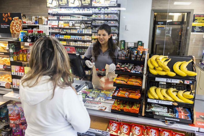 Owner Shweta Sharma, center, helps a customer at her 7-Eleven store in Phinney Ridge in Seattle on Thursday, June 15, 2023. (Daniel Kim / The Seattle Times)