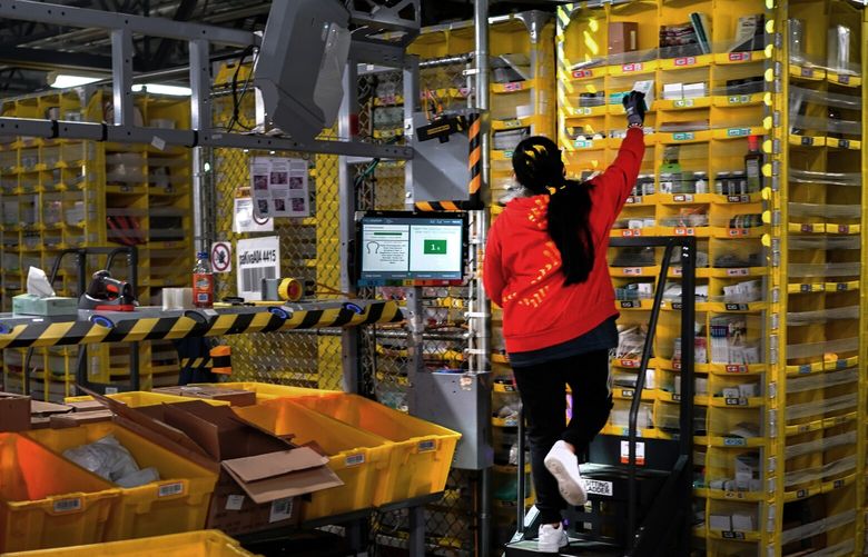 FILE – An Amazon employee sorts items into the waiting robots at the company’s facility on Staten Island in New York on March 2, 2021. Amazon has eclipsed Walmart to become the world’s largest retail seller outside China, according to corporate and industry data. (Chang W. Lee/The New York Times)