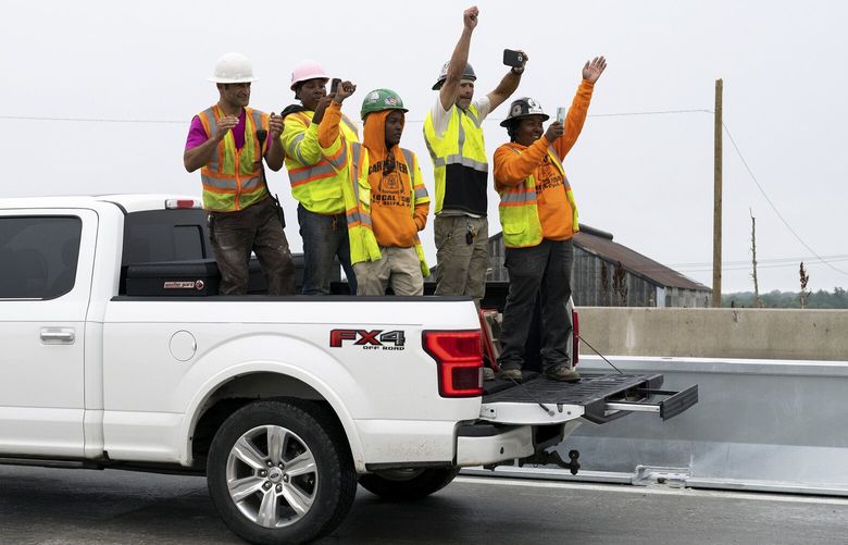 Employees with Buckley & Co. cheer as Interstate 95 is reopened on Friday, June 23, 2023, in Philadelphia. Buckley & Co. was contracted by the state to rebuild the I-95 bridge. (AP Photo/Joe Lamberti) PAJL2001 PAJL2001