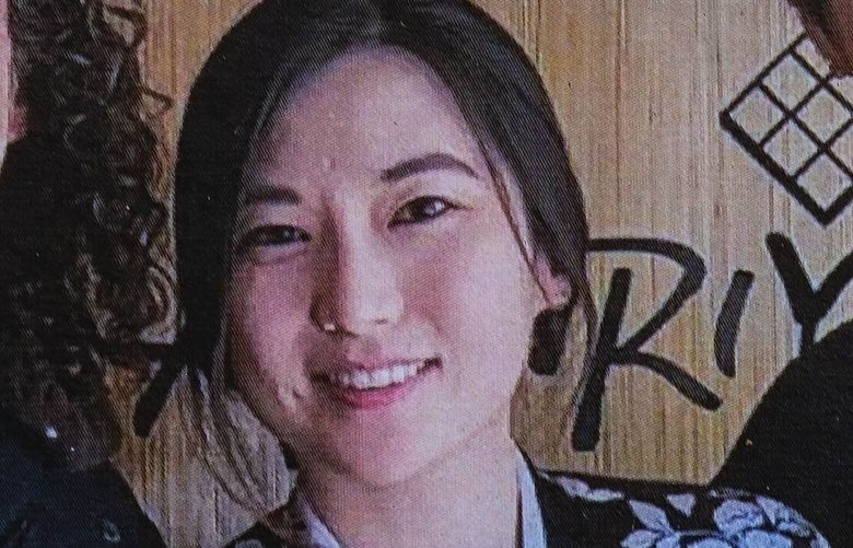 A photograph, believed to be of Eina and Sung Kwon, appears on the door outside their Belltown restaurant.  Appearing with them is famed Seattle musician Kenny G. 224210