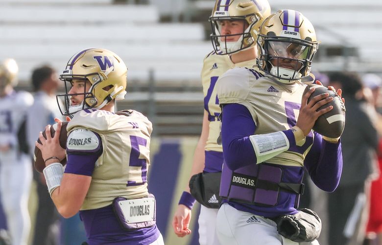 UW quarterbacks Dylan Morris, left, and Michael Penix, Jr. drops back to pass Friday morning during practice at Husky Stadium in Seattle, Washington on April 14, 2023.
