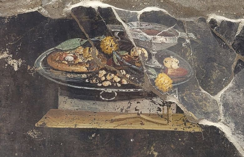 This picture provided on Tuesday, June 27, 2023, by the Pompeii Archaeological Park shows the wall of an ancient Pompeian house with a fresco depicting a table with food. The fresco was found in the atrium of a house in Insula 10 of Regio IX under excavation, to which a bakery was annexed, already partially explored between 1888 and 1891 and whose investigations were resumed last January. (Pompeii Archaeological Park via AP, ho) XDS102 XDS102