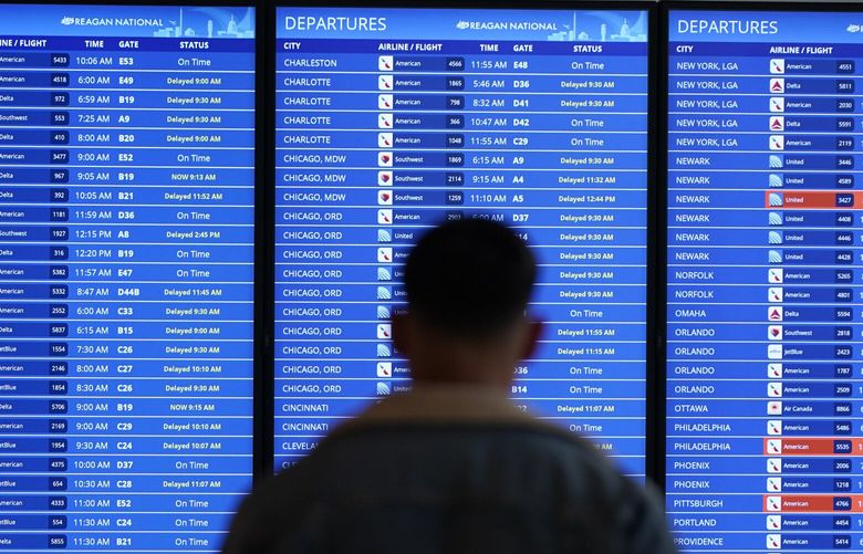 FILE – A traveler looks at a flight board with delays and cancellations at Ronald Reagan Washington National Airport in Arlington, Va., Wednesday, Jan. 11, 2023. Thousands of air travelers faced flight cancellations and delays this weekend as thunderstorms traveled across the U.S. East Coast and Midwest. (AP Photo/Patrick Semansky, File) NYPM102 NYPM102