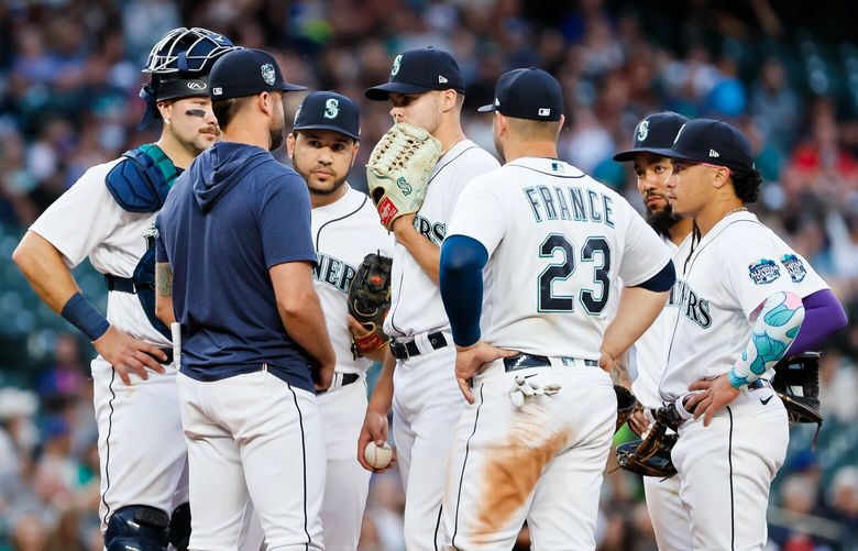 Teammates gather around Seattle Mariners relief pitcher Matt Brash during the seventh inning. 224265