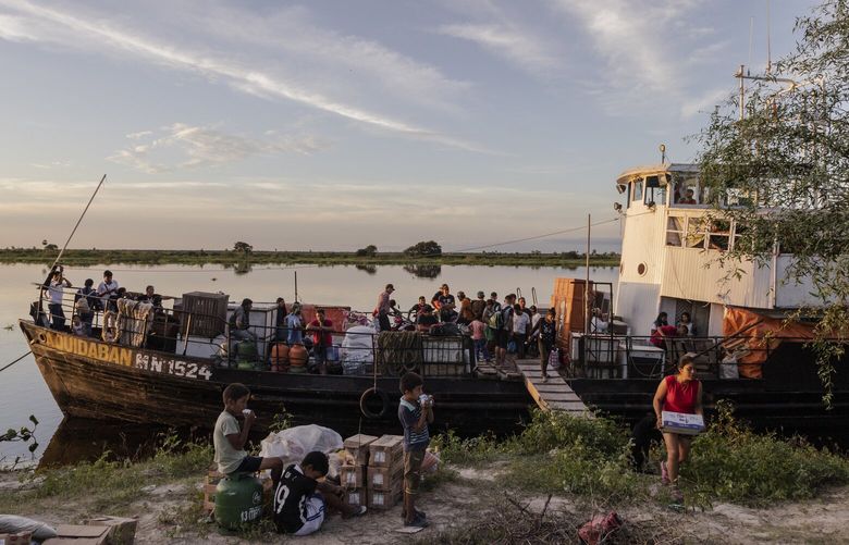 The Aquidaban, the only ferry in one of South America’s most remote stretches, docked at  Puerto Esperanza, a Chamacoco Indigenous community near Bahía Negra, Paraguay on May 5, 2023. For 44 years, the 130-foot white, wooden vessel has been the only regular ferry service to reach this deep into the Pantanal, a floodplain larger than Greece, traveling 500 miles up and down the Paraguay River Tuesdays to Sundays, delivering everything from dirt bikes to newborns. (María Magdalena Arréllaga/The New York Times) XNYT0327 XNYT0327