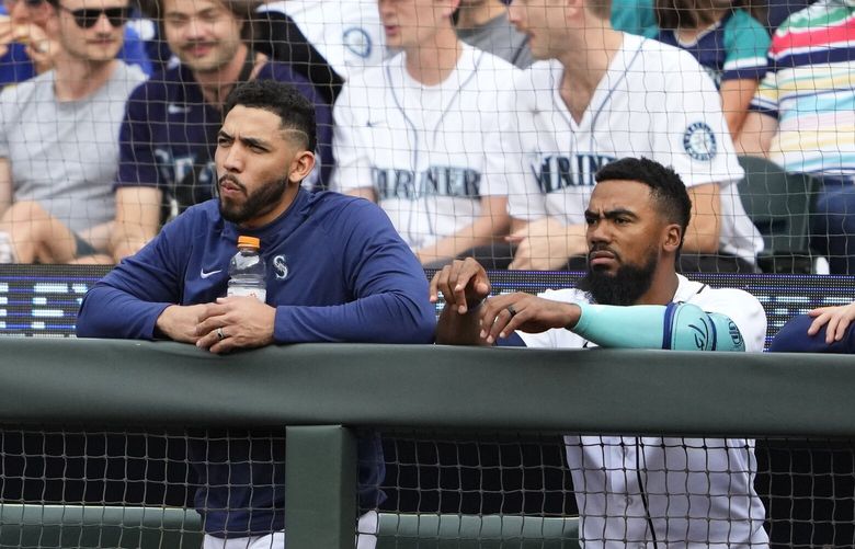 Seattle Mariners second baseman Jose Caballero stands with right fielder Teoscar Hernandez at the railing as they watch a baseball game against the Washington Nationals, Tuesday, June 27, 2023, in Seattle. (AP Photo/Lindsey Wasson) OTK OTK
