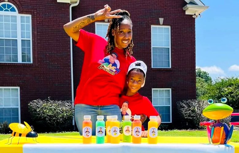 Cristal Johnson and her 8-year-old son, Cameron, with the lemonade stand they turned into Cam’s Lemonade, a company that distributes lemonades to restaurants and grocery stores in Alabama. MUST CREDIT: Cristal Johnson