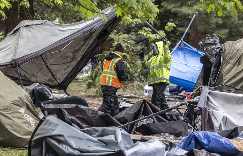 Tuesday, May 10, 2022.   Seattle Parks employees and contractors start taking down the remaining homeless tent structures in Woodland Park near the lawn bowling center.   220345
