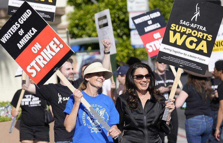 FILE – Meredith Stiehm, left, president of Writers Guild of America West, and Fran Drescher, president of SAG-AFTRA, take part in a rally by striking writers outside Paramount Pictures studio in Los Angeles on May 8, 2023. Hollywood actors may be on the verge of joining screenwriters in what would be the first two-union strike in the industry in more than six decades. (AP Photo/Chris Pizzello, File) NYET468 NYET468